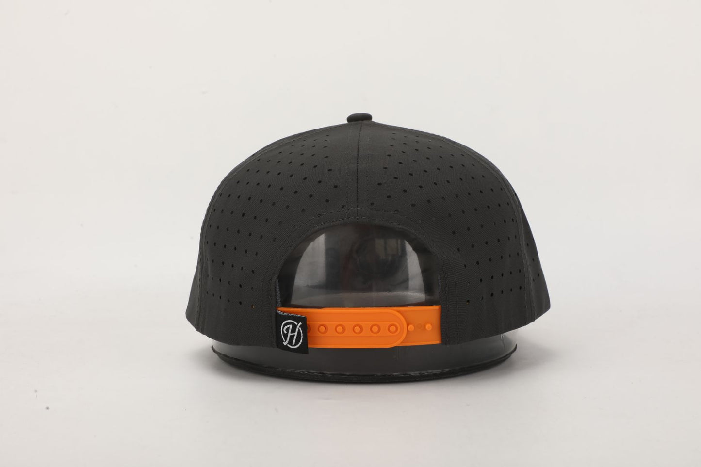 Black cap with orange strap on a light gray background