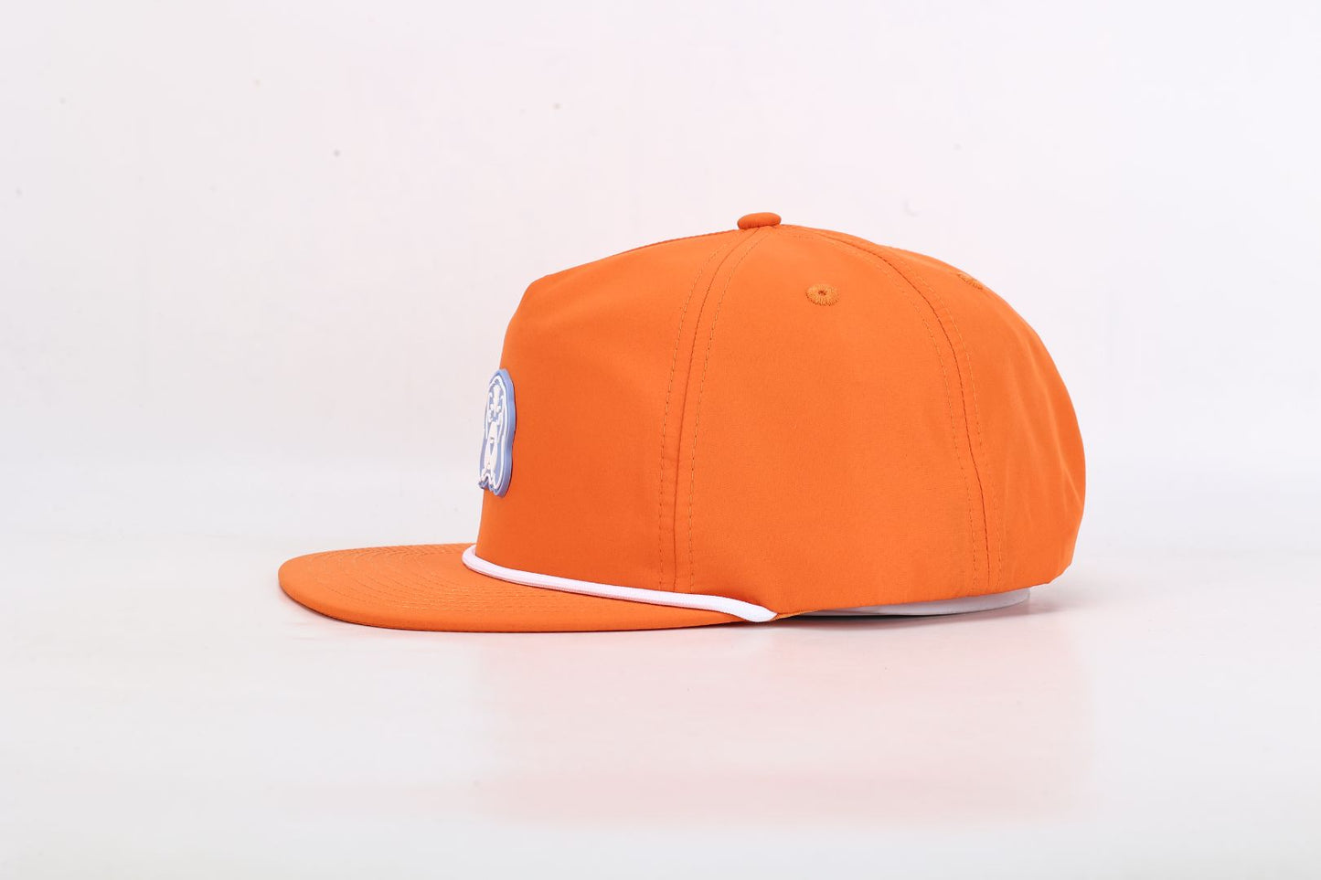 Orange cap with a logo on a light pink background