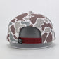 Camouflage-patterned cap with a red band and logo on a light gray background