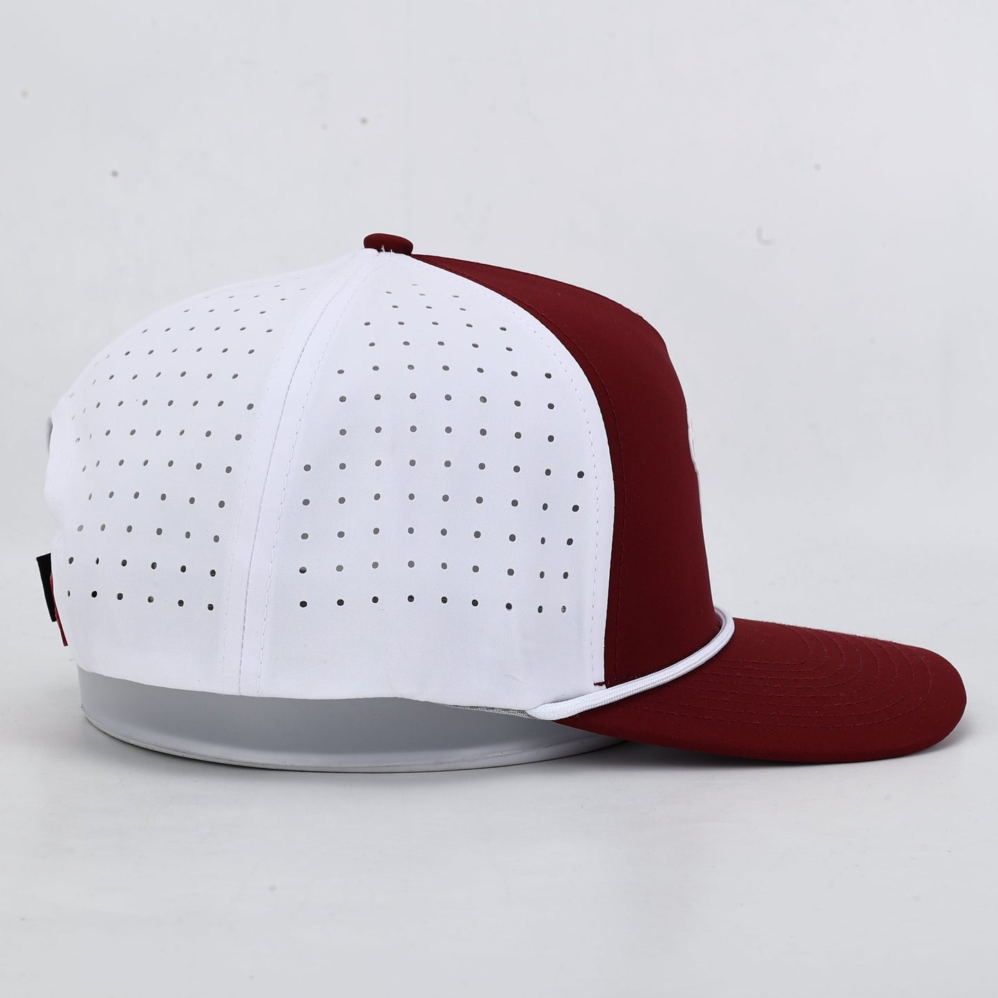 White and maroon baseball cap on a light gray background