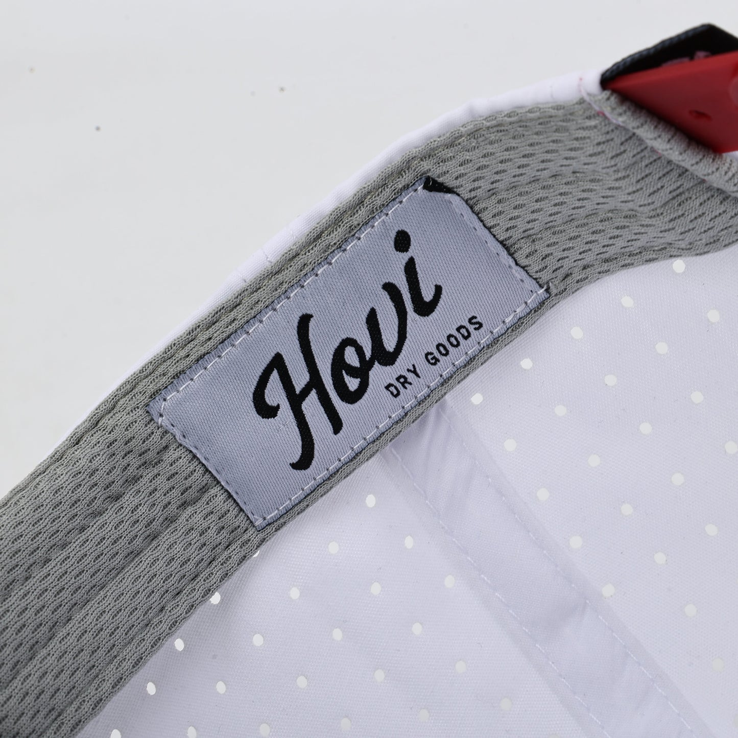 Close-up of a cap with a 'Hovi' brand label on a white background